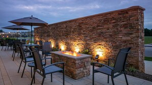 An outdoor patio area with stone walls, seating, and a fire feature. - Fairfield Inn & Suites by Marriott Lebanon near Expo Center (Lebanon)