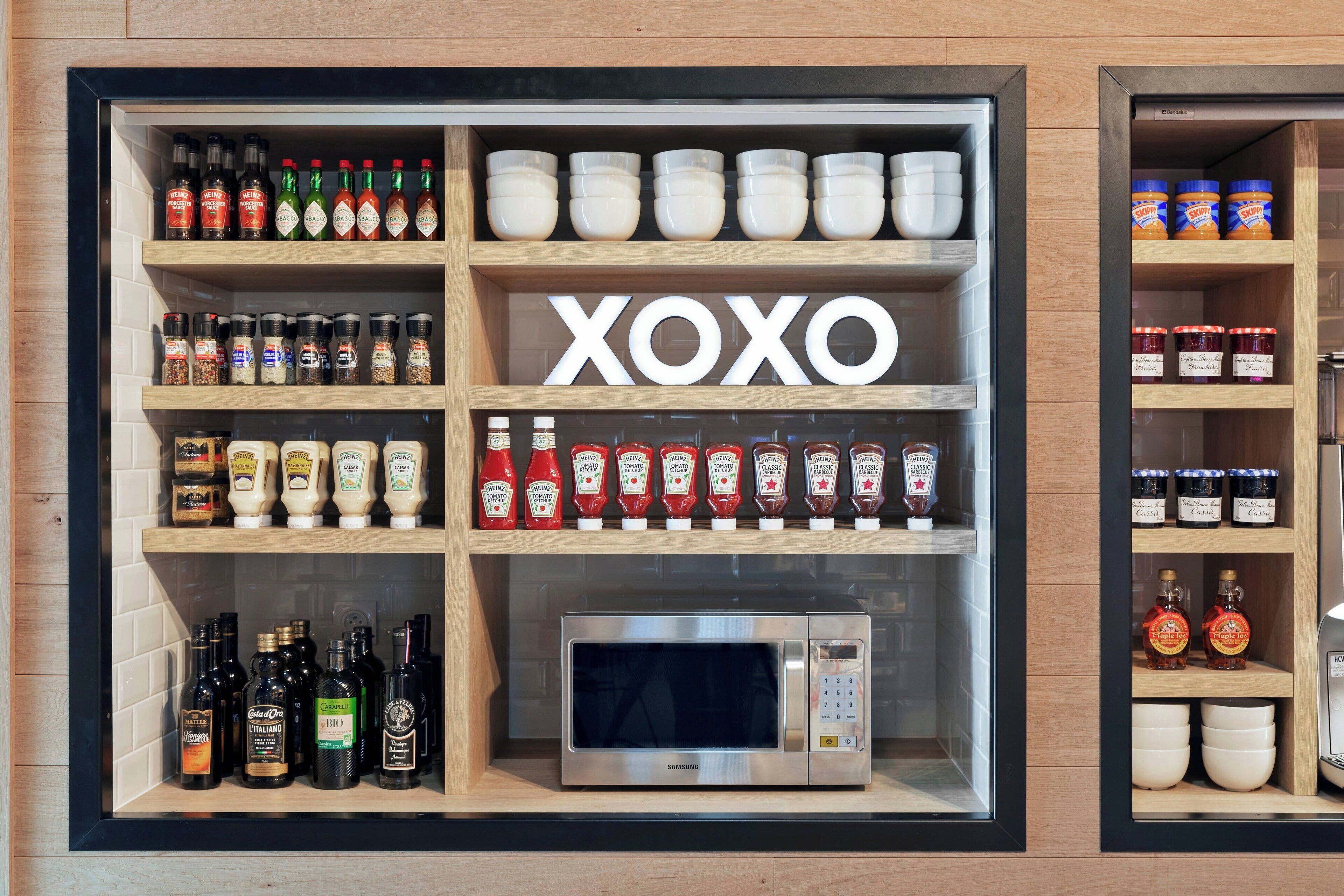 Eine Küche mit verschiedenen Gewürzen, einer Mikrowelle und einem großen 'XOXO'-Schild.