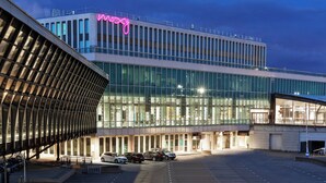 A modern building with a glass facade and a neon sign. - Moxy Lyon Airport (Colombier-Saugnieu)