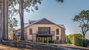 A two-story house with a balcony, stone foundation, and large windows. - Rustic charm amongst the vines in Pokolbin (Pokolbin)