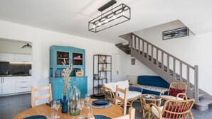 A modern living space with a dining area, kitchen, and staircase. - Bretagne by Interhome (Carnac)
