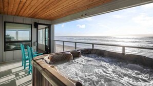 Un jacuzzi sur un balcon avec vue sur l’océan.