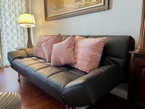 Relax in this stylish living room with a comfortable sofa, floor lamp, and artwork on the wall.