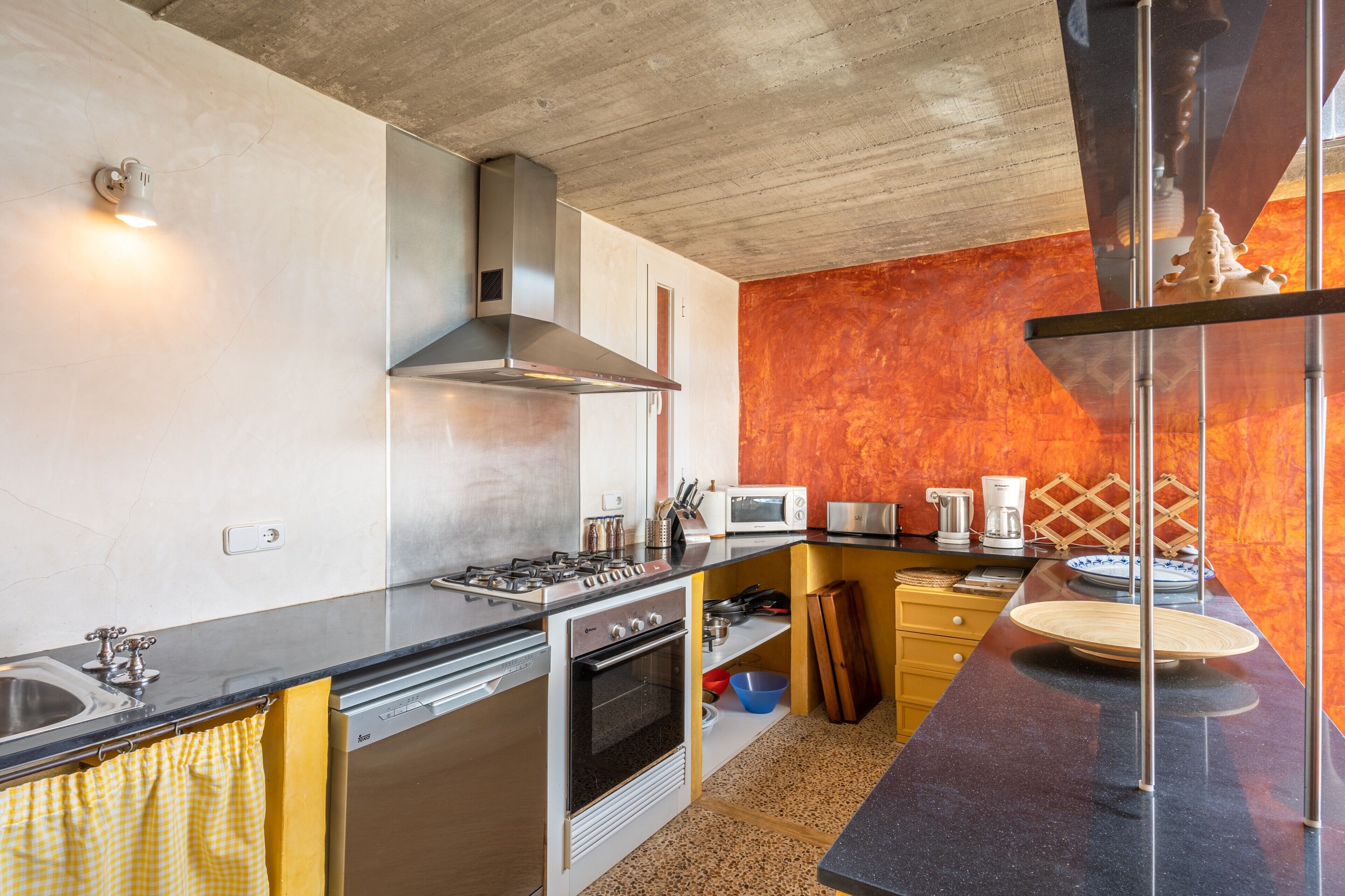 A kitchen with a stove, oven, microwave, and modern appliances.