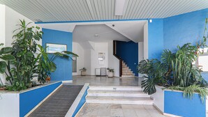 Ein modernes Interieur mit blauer Akzentwand, einer Treppe und Topfpflanzen.