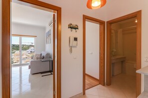 Un appartement moderne comprenant un espace de vie, une salle de bain et offrant une vue sur le paysage urbain.