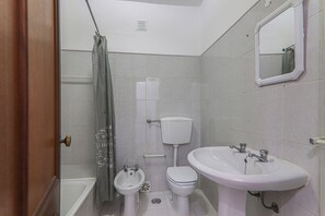 A bathroom with a bathtub, a bidet, a toilet, and a sink. - Torre Sol 909 Beach Apartment with Pool, Garden, and Balcony (Armação de Pêra)