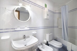 Une salle de bain avec un lavabo, des toilettes et une douche.