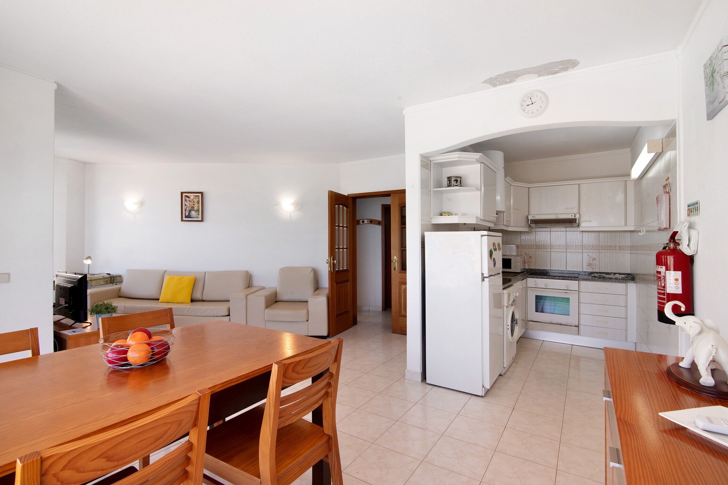 A compact living space with a dining area, kitchenette, and a sofa in the living room.