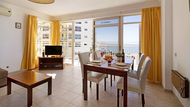 Un comedor con una mesa, sillas y un televisor.
