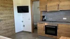 Eine kleine Küche mit Holzausstattung, einem Backofen und einer Kaffeemaschine.