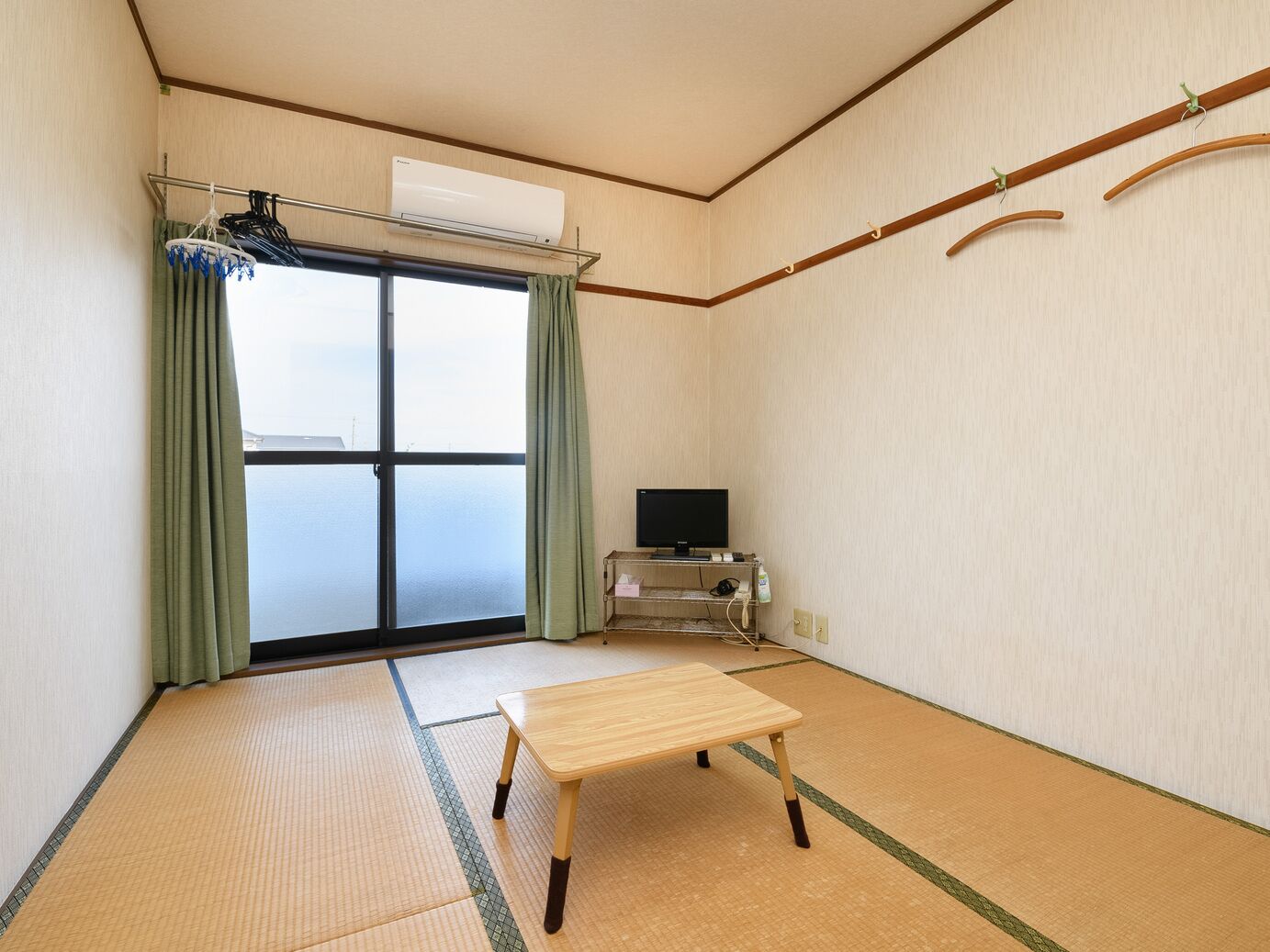 Ein Zimmer mit Tatami-Boden, Futonbett, Fernseher und Meerblick.
