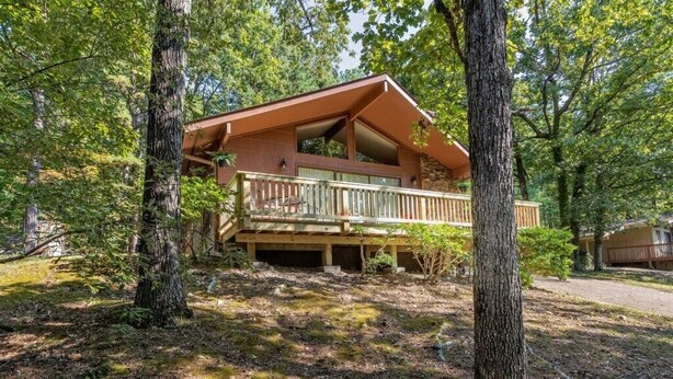 Eine Hütte mit Balkon, umgeben von Bäumen.