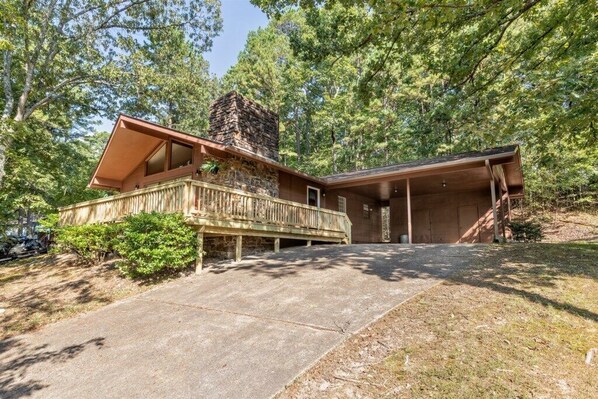 A cabin with a stone chimney, wooden deck, and a covered porch. - 05210 - 8 South Pego Way (Hot Springs)