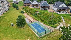 Zona residencial con varias casas, una cancha de tenis y un parque infantil.