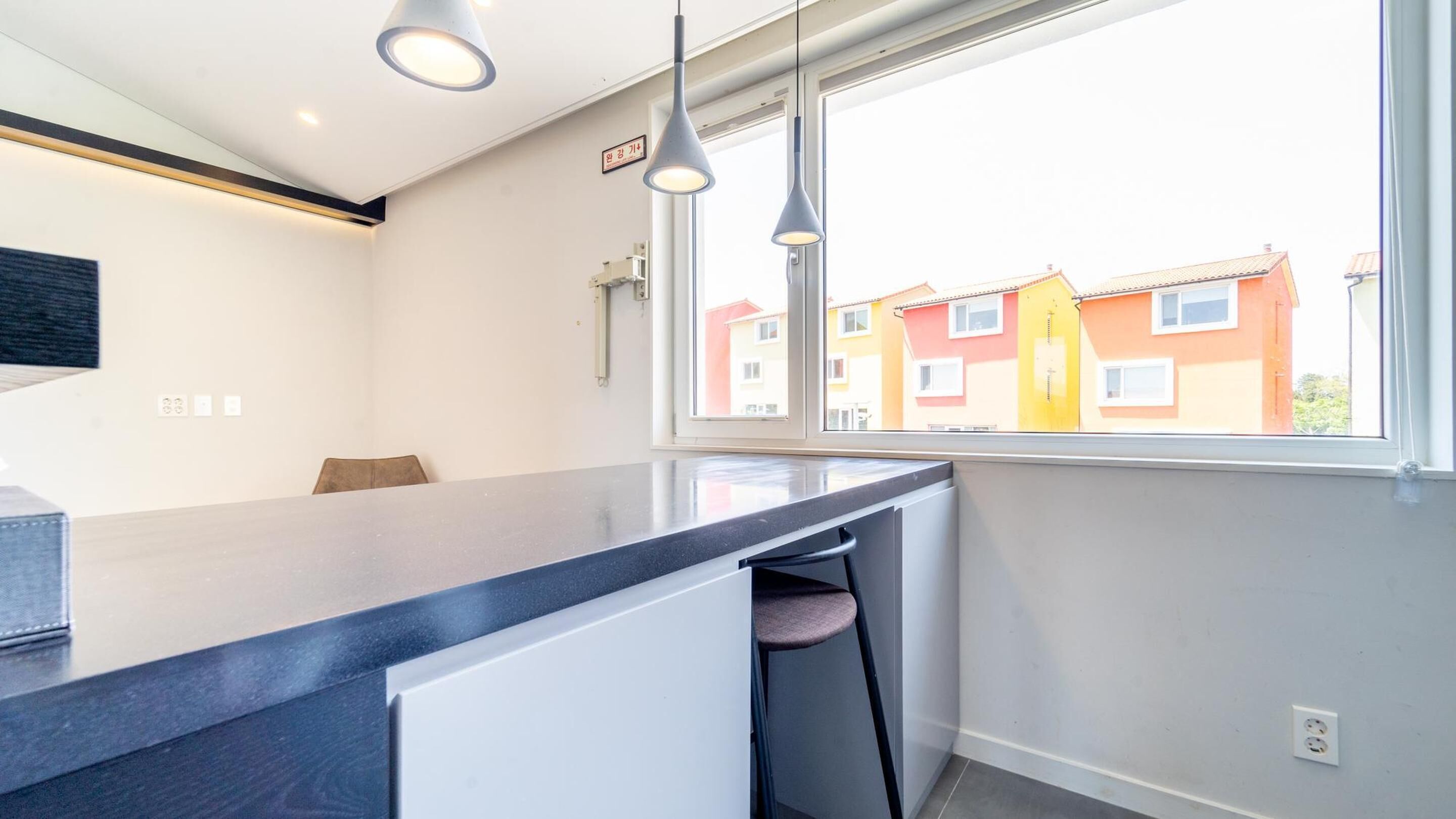 A modern kitchen with a large window, a built-in oven, and a countertop.