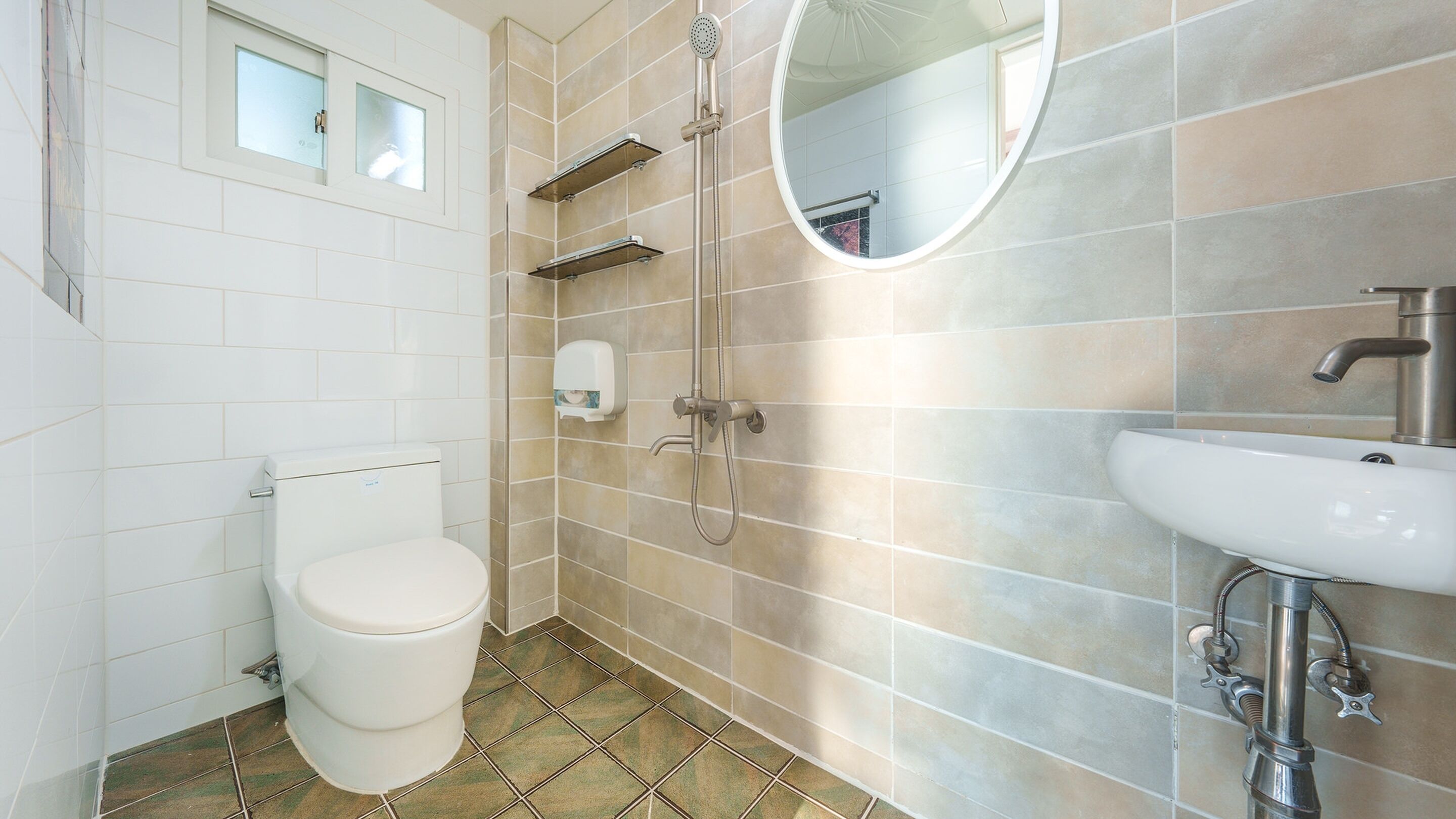 Une salle de bain comprenant des toilettes, une douche, un lavabo et un miroir.