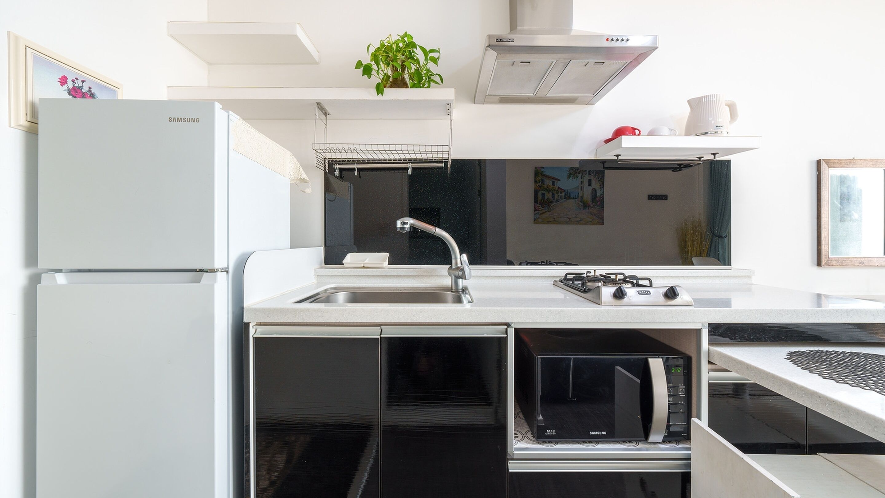 Una cocina moderna con horno integrado, microondas y estufa a gas.