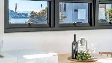 A kitchen with a view of a bridge and trees through the windows.