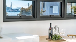 Une cuisine avec vue sur un pont et des arbres, visible à travers les fenêtres.