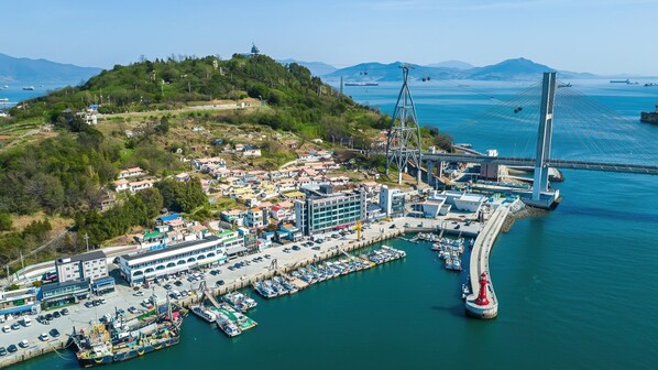 A coastal cityscape with a prominent bridge, marina, and residential buildings. - Yeosu Nangmanstay Pension (Yeosu)