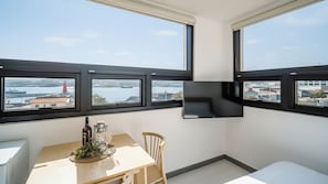 Una habitación con una mesa, una silla y un televisor montado en la pared.