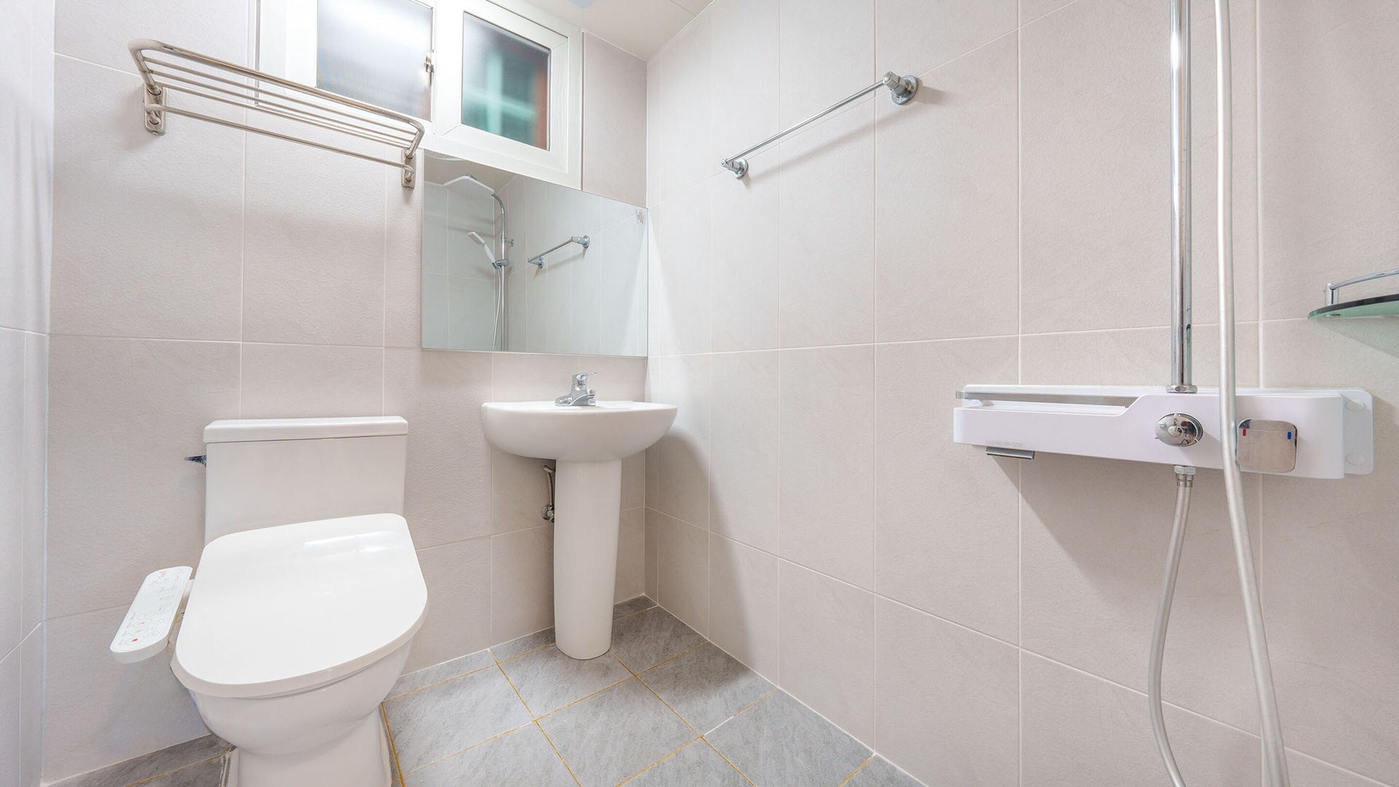 A modern bathroom with a toilet, sink, and shower.