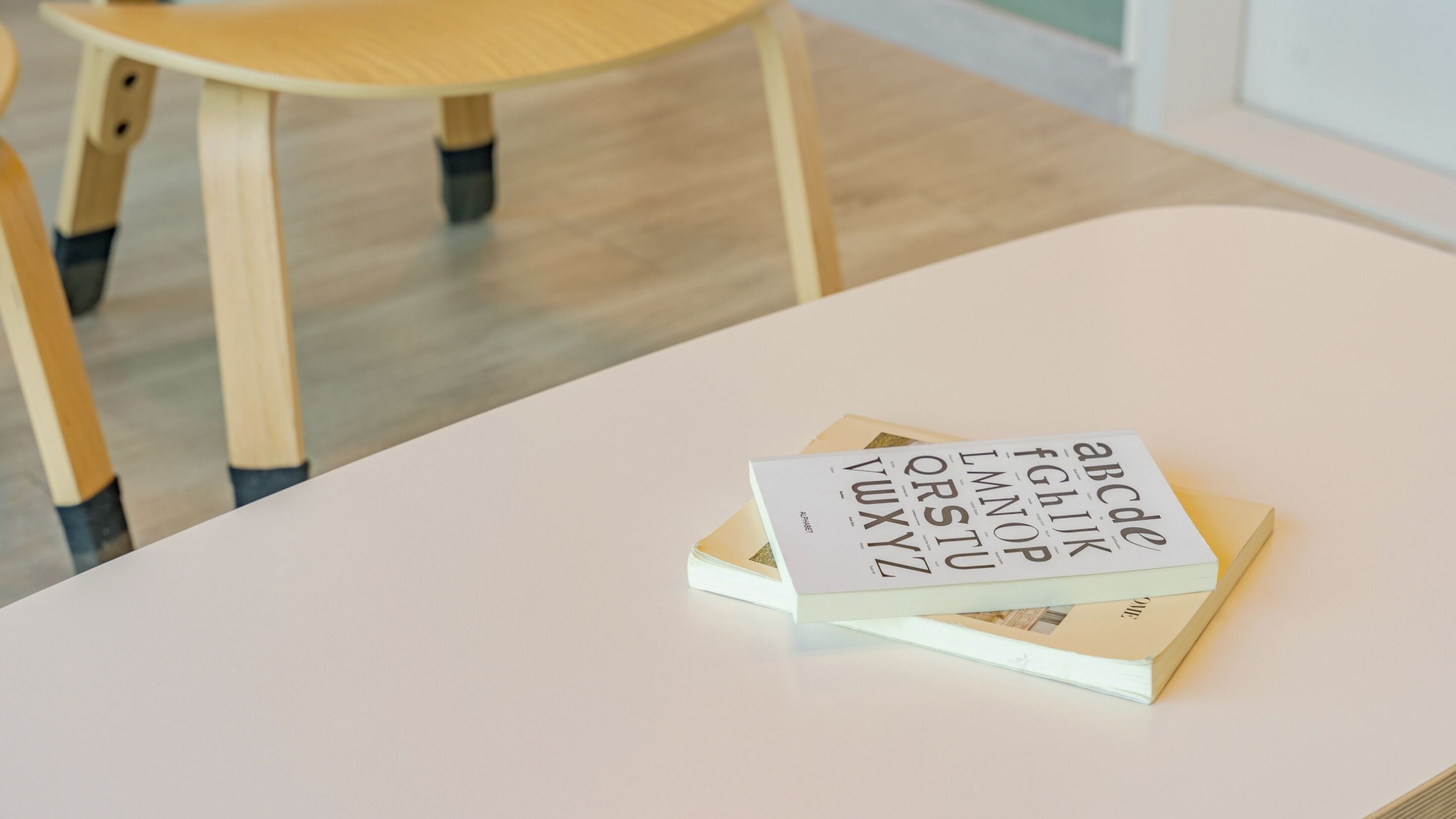 Una mesa blanca con un libro titulado "The Art of Typography" y otro libro debajo.
