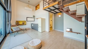 Un appartement moderne doté d’une cuisine, d’un coin repas et d’un escalier.