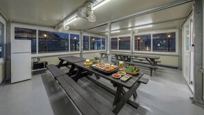 Una zona de dinar a l'interior amb taules, bancs i diferents aliments.