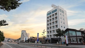 Un hotel moderno con varios pisos, un letrero llamativo y una vista despejada de la calle.
