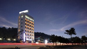 A multi-story hotel with illuminated balconies and a starry night sky. - Yangyang Eight (Yangyang)