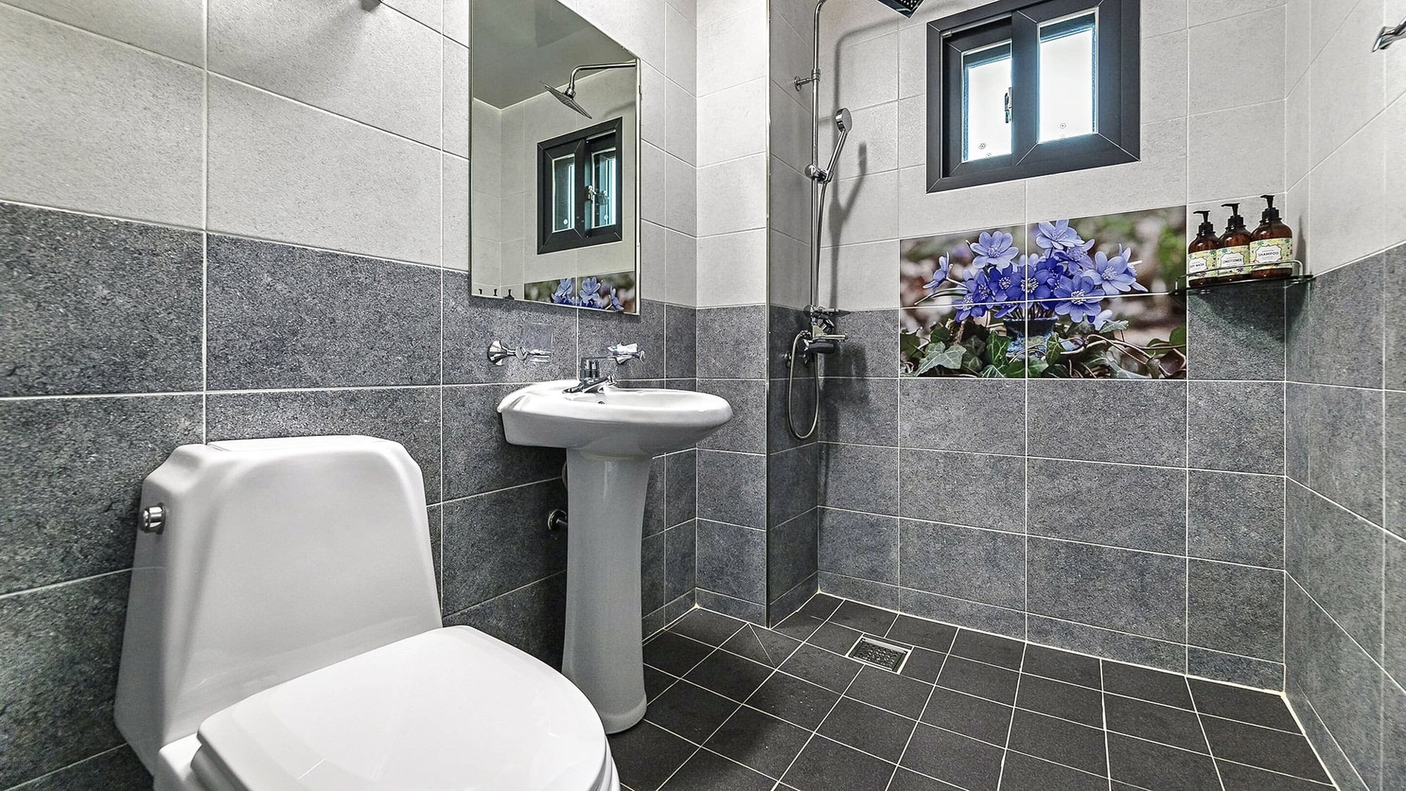 A bathroom with a toilet, sink, and shower.