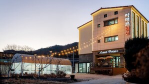 A building with a sign reading "Lamer Pension" and a covered outdoor seating area. - Samcheok Lamer Pension (Samcheok)