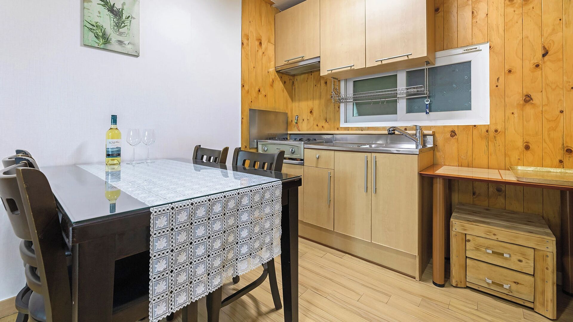 Una cocina compacta con armarios de madera, horno empotrado y una ventana pequeña.