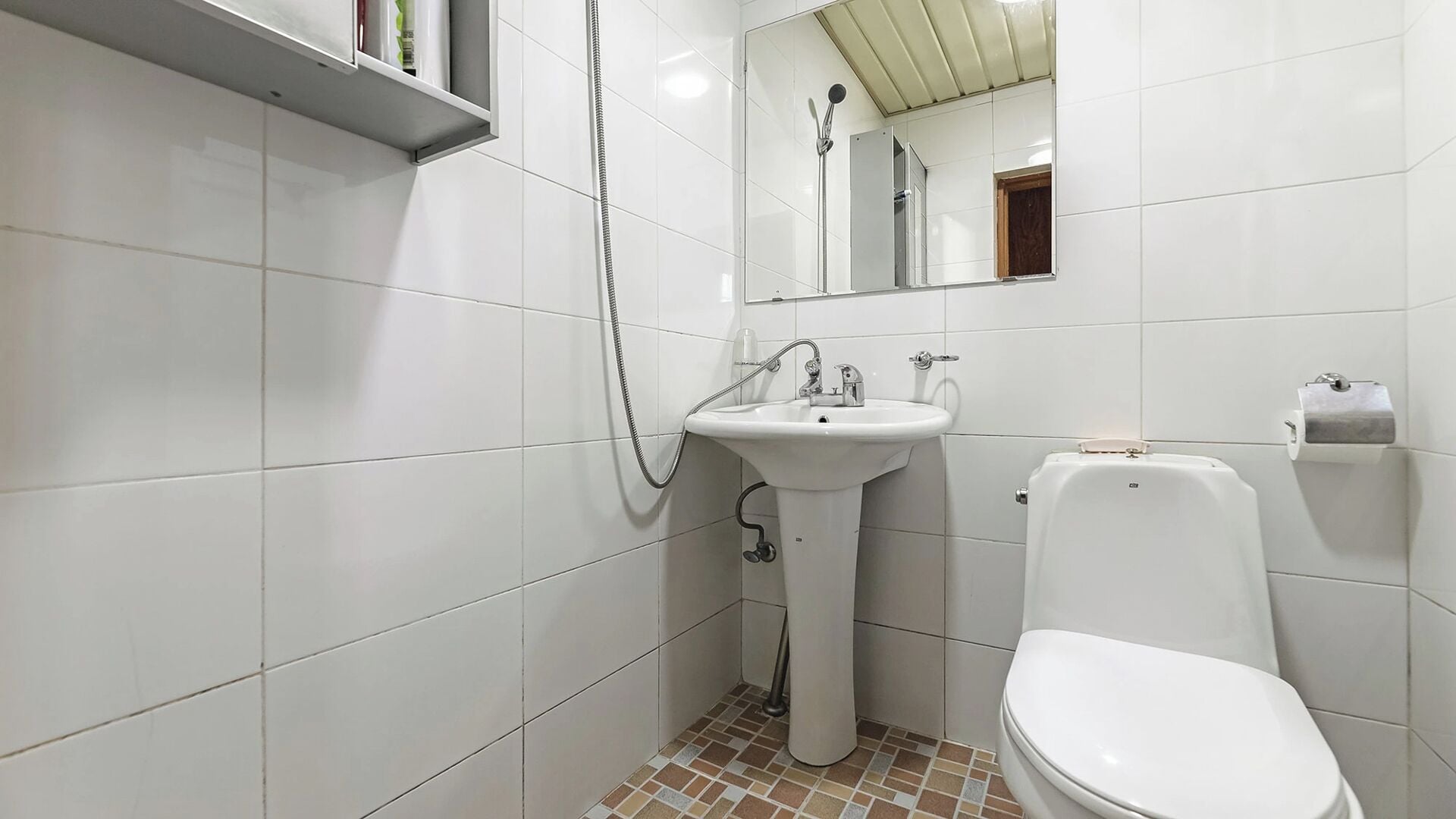A bathroom with a white sink, a toilet, and a shower.