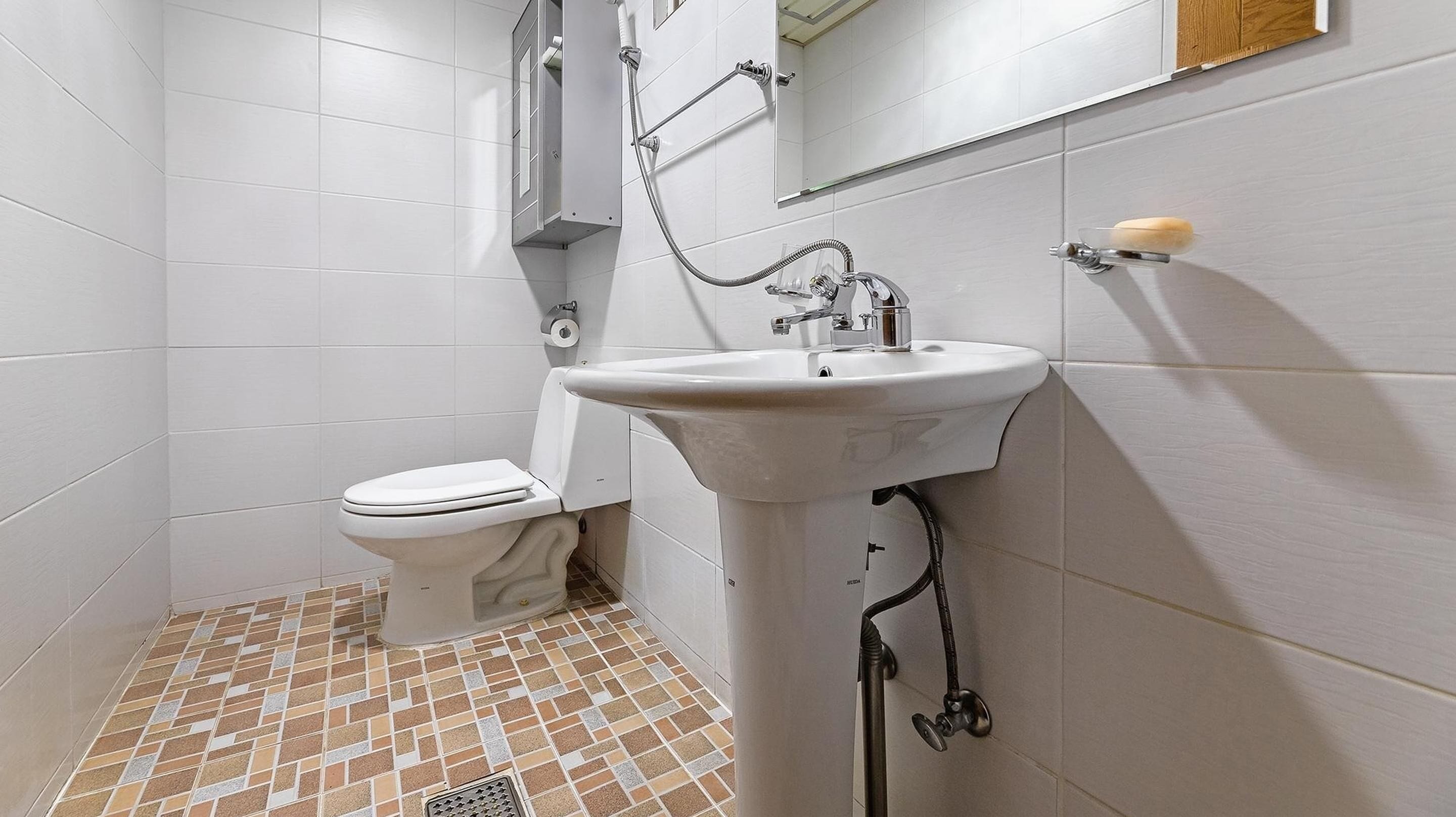 Une petite salle de bain avec des toilettes, un lavabo et une douche.