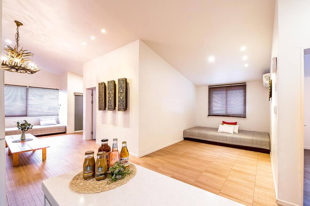 A modern interior with a dining area, a seating area with a sofa and a bench, and a kitchenette.