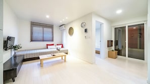 Un dormitorio moderno con cama, mesita de noche y ventana con persianas.