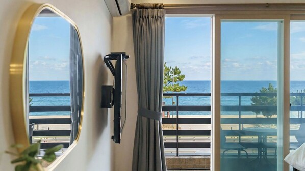 A room with a large window overlooking a beach, a door, and a wall-mounted light fixture. - Yangyang Haetteuneun Changmun Pet-friend (Yangyang)