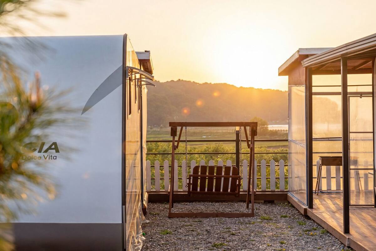 A balcony with a swing, a view of the countryside, and a sign with 'CIA Dolce Vita'.