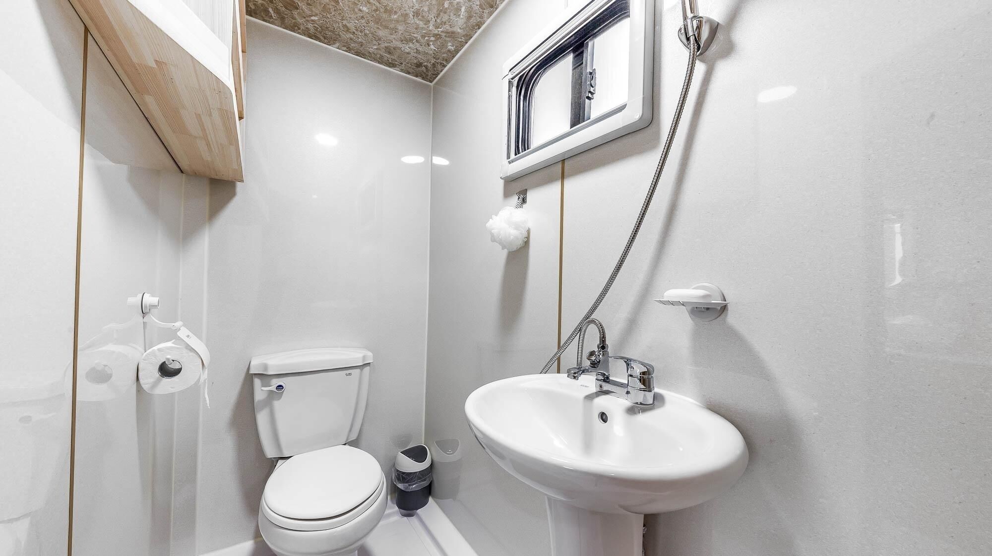Ein kleines Badezimmer mit Toilette, Waschbecken und Dusche.