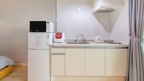 Una cocina compacta con microondas, tostadora y lavabo.