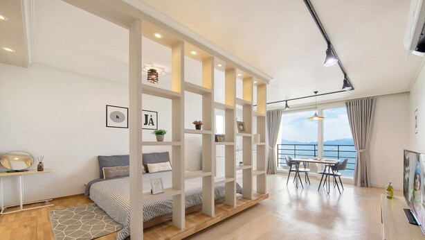 Un dormitorio moderno con cama, escritorio y zona de comedor.
