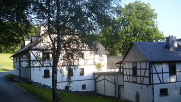 A traditional half-timbered building with a sign reading 'GASTHOF' and a small adjacent structure.