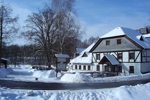 A snow-covered building with a sign reading 'Gastrop Teichmühle.' - Doppelzimmer - Braunes Zimmer - Gasthof Teichmühle (Leubnitz)