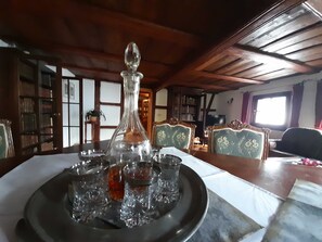 A dining area with a wooden table, a decorative glass pitcher, and a tray with glasses.