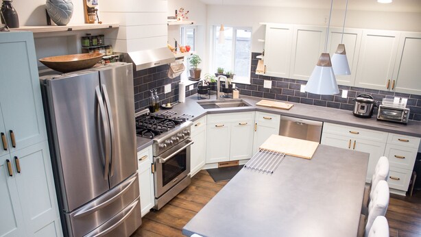 A modern kitchen with stainless steel appliances, white cabinets, and a central island. - Modern Midtown Home w/ Luxury Finishes & Hot Tub! (Bend)