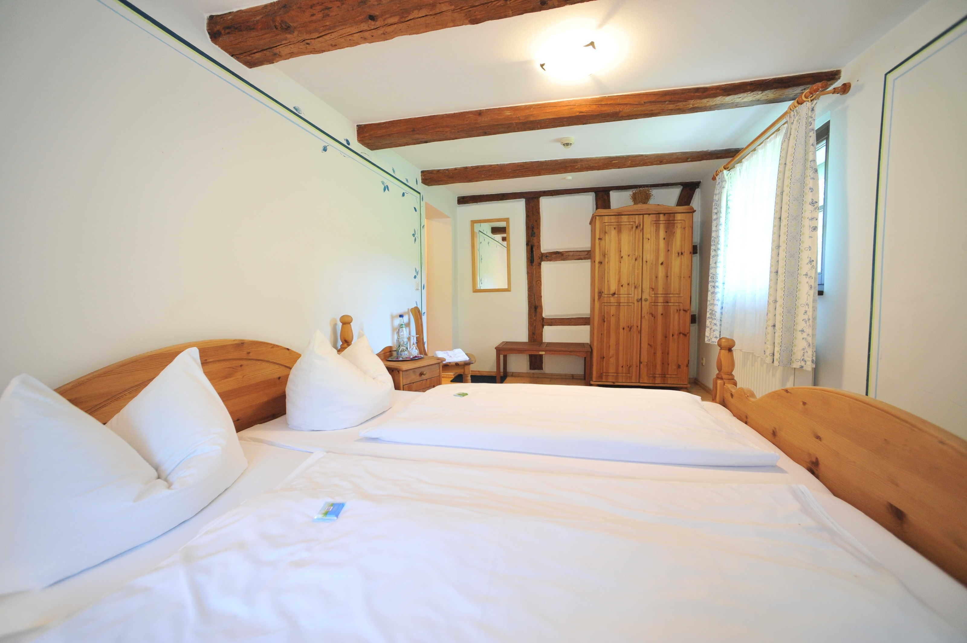 Une chambre à coucher avec une tête de lit en bois, une armoire en bois et une table de chevet avec une lampe.