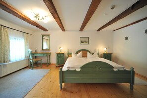Un dormitorio con una cama de madera, un escritorio y una silla.